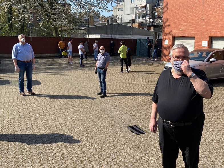 Helfer der Tafel Frechen bei der Einweisung auf dem Parkplatz am Pfarrheim St. Audomar